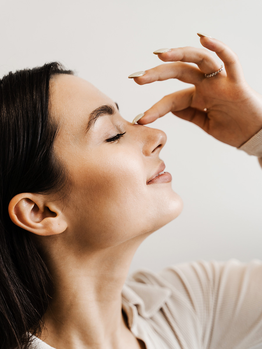 Young woman touching the tip of her nose